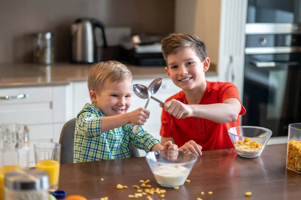 Zwei fröhliche Kinder genießen ihr morgendliches Essen — Stockfoto