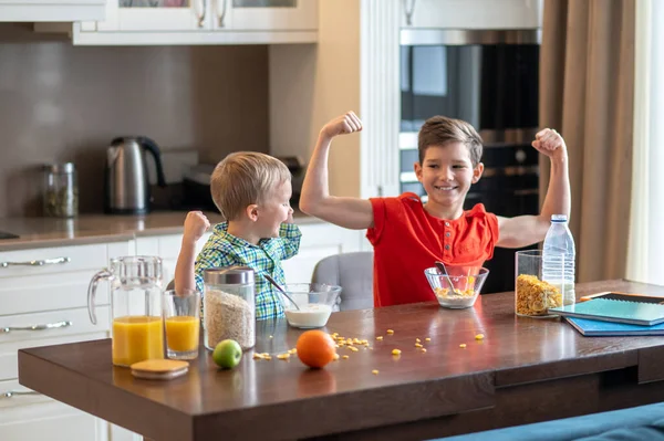 Kinder zeigen ihre körperliche Fitness nach dem Frühstück Müsli essen — Stockfoto