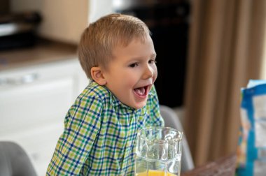 Çocuk ağzı açık mutfak masasına yaslanmış.