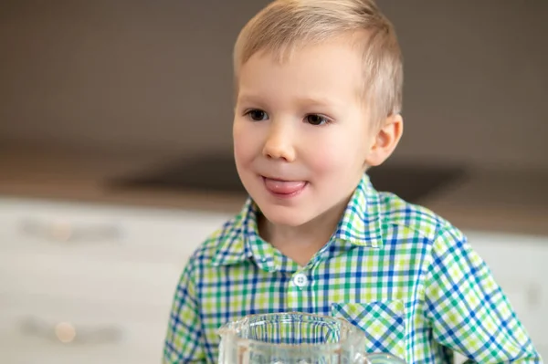 Kid with his tongue stuck out staring into the distance — Stock Photo, Image