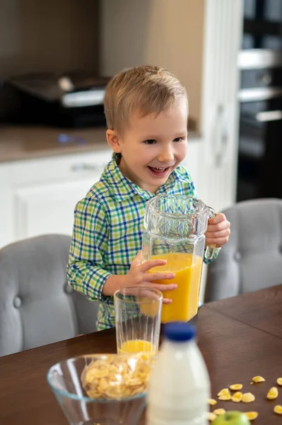 Zufriedenes Kind mit Glaskrug in der Küche — Stockfoto