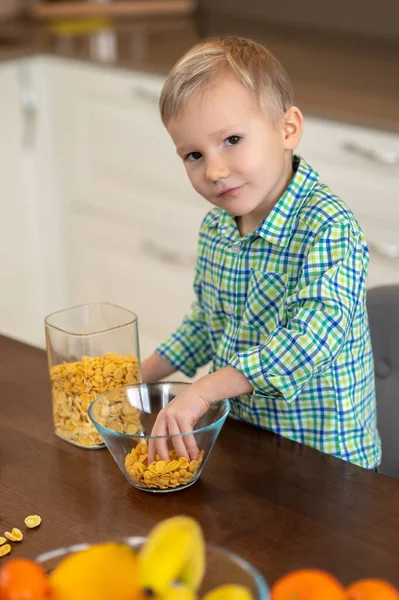 Niño tranquilo haciendo su desayuno en la cocina — Foto de Stock