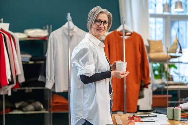 Femme avec tasse debout sur le côté tourné la tête à la caméra — Photo