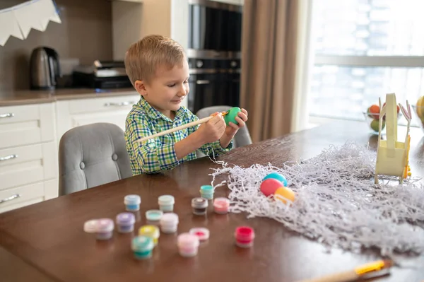 Kid busy with decorating eggs for Easter — Stock Photo, Image