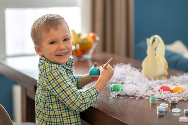 Cheerful boy posing for the camera during Easter egg decoration — Stock Photo, Image