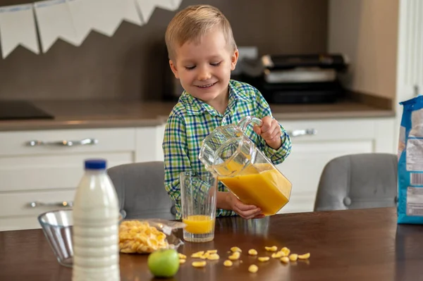 陽気なかわいい子供が柑橘類の飲み物でガラスを充填 — ストック写真