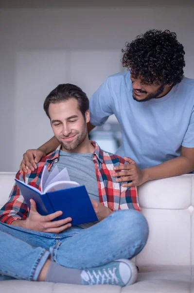 Uomo che legge un libro in presenza del suo fidanzato — Foto Stock