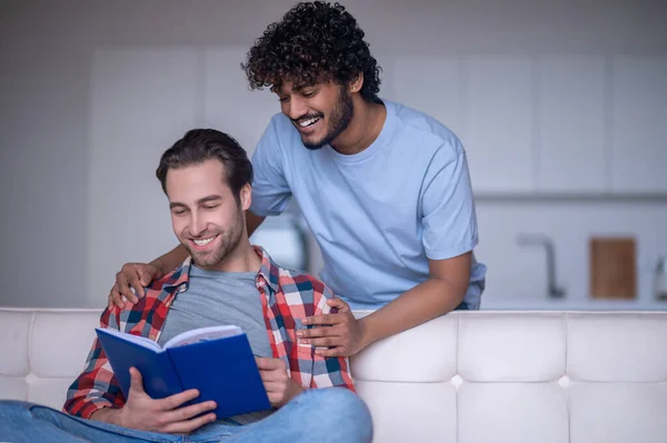 Alegre biracial gay casal focado no leitura — Fotografia de Stock