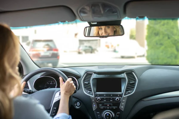 Mulher dirigindo carro olhando no espelho retrovisor — Fotografia de Stock