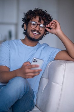 Geleceğe bakan cep telefonlu neşeli adam.