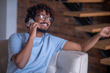 Akıllı telefonuyla konuşan neşeli çekici adam.