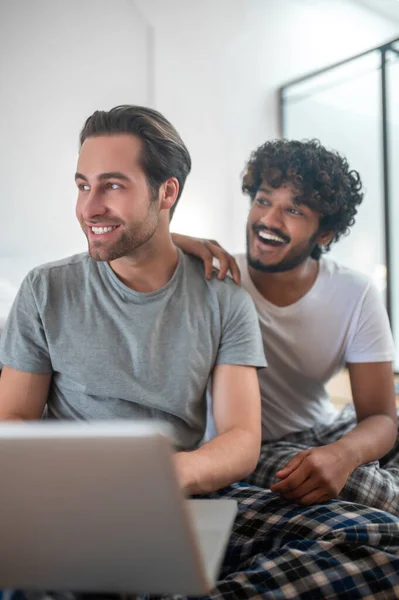 Vrolijk gay paar zitten aan de draagbare computer — Stockfoto