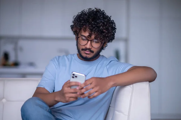 Zaměřený indián čtení textové zprávy na jeho gadget — Stock fotografie