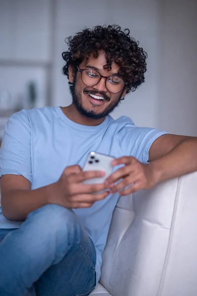 Радостный молодой человек, читающий СМС — стоковое фото
