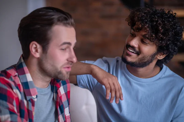 Biracial gay casal ter um conversa dentro de casa — Fotografia de Stock