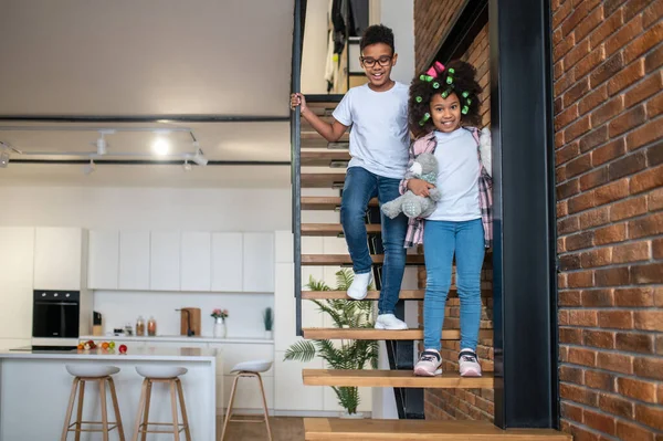 Ragazzo e ragazza scendendo le scale a casa — Foto Stock