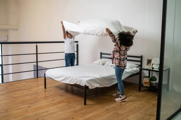 Barn lyfter händerna högt med lakan över sängen — Stockfoto
