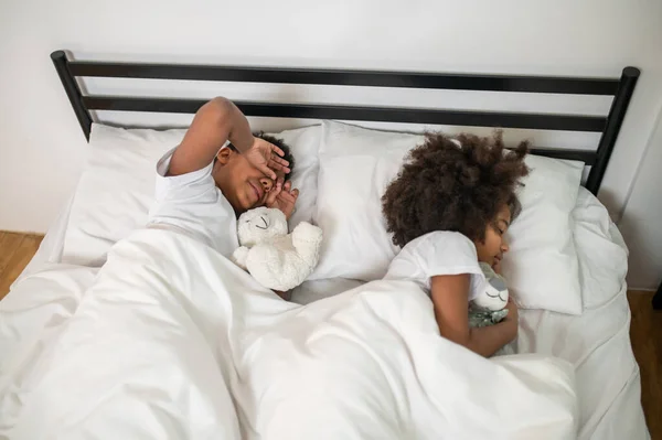 Bovenaanzicht van jongen en meisje slapen in bed — Stockfoto