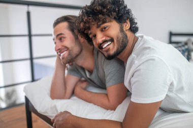 Aşık bir adam mutlu erkek arkadaşına sarılıyor.