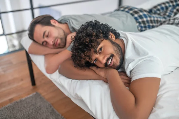 Мужчина и его парень отдыхают в своей спальне — стоковое фото