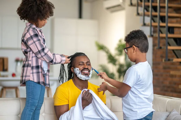 아빠를 면도 하는 소년 과 머리를 짜는 소녀 — 스톡 사진