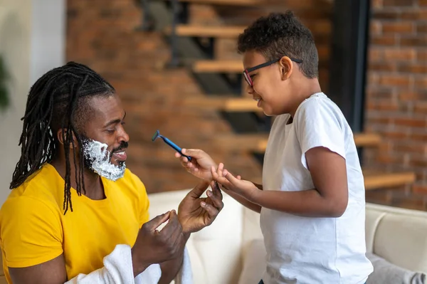 Boy with razor and dad sideways to camera — Stock Photo, Image