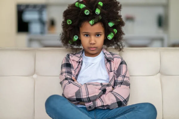 Afroamerykanka dziewczyna patrząc na aparat siedzi na kanapie — Zdjęcie stockowe