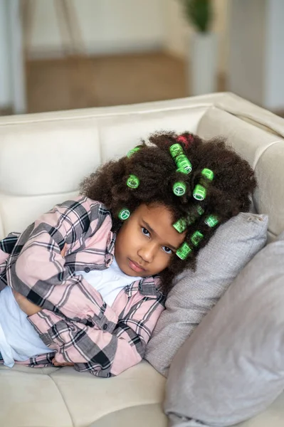 Africano chica americana acostado en sofá mirando a la cámara — Foto de Stock