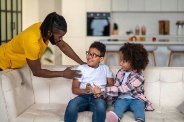Baba oğluna dokunuyor, kız kardeşinden akıllı telefon alıyor.