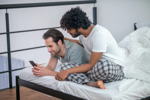 Dos hombres gay viendo fotos en el teléfono inteligente — Foto de Stock