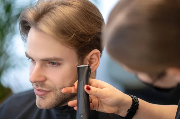 Светловолосый мужчина, проходящий парикмахерские процедуры в салоне красоты — стоковое фото