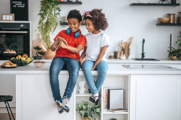 Twee broers en zussen hebben het naar hun zin thuis en voelen zich vrolijk — Stockfoto