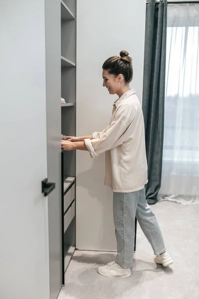 Una joven haciendo quehaceres domésticos y con aspecto de ocupada — Foto de Stock