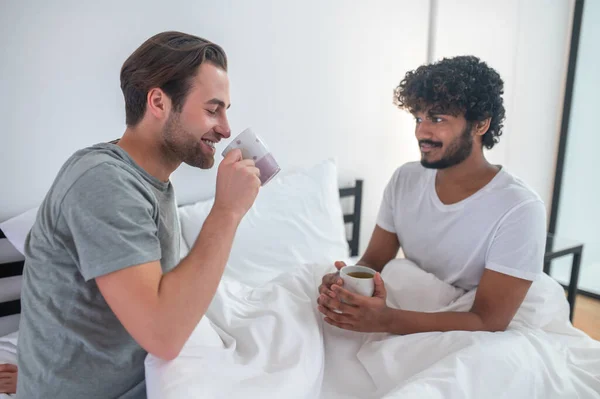 Tipo romántico mirando a su compañero con una taza de té — Foto de Stock