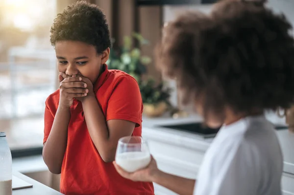 Ein Junge im roten Hemd weigert sich, Milch zu trinken — Stockfoto