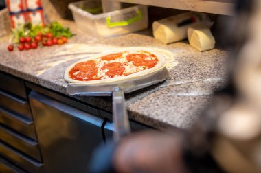 İtalyan şef aşçı restoranda pizza pişiriyor.