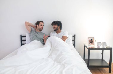 Genç adam neşeli erkek arkadaşıyla konuşuyor.