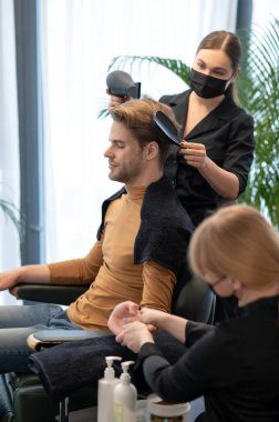 Güzellik salonunda güzellik prosedürleri uygulayan bir adam.