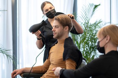 Güzellik salonunda güzellik prosedürleri uygulayan bir adam.