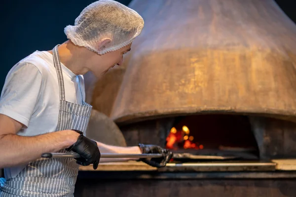 Italian chief-cooker baking pizza in the restaurant — Stock Photo, Image
