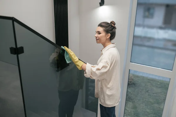 Jonge donkerharige vrouw die de trap schoonmaakt — Stockfoto