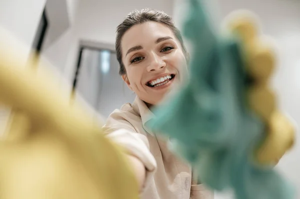 Close up foto van een lachende vrouw in gele handschoenen — Stockfoto