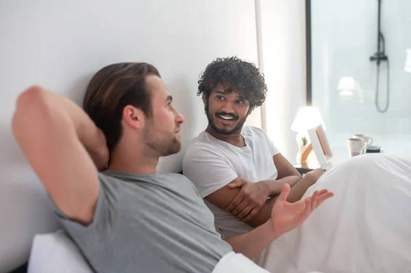 Hombre alegre mirando a su novio durante su conversación íntima — Foto de Stock