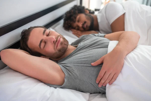 Гей-пара ложится в постель во время утреннего сна — стоковое фото