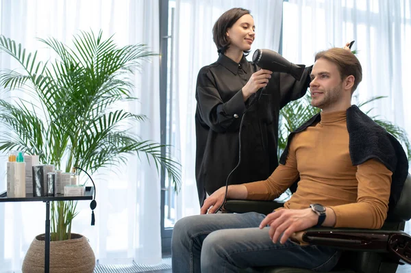 Peluquería de pelo largo trabajando con un cliente masculino en la bofetada de belleza — Foto de Stock