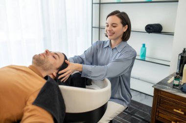 Güzellik uzmanı saç tedavi prosedürleri sırasında baş masajı yapıyor.