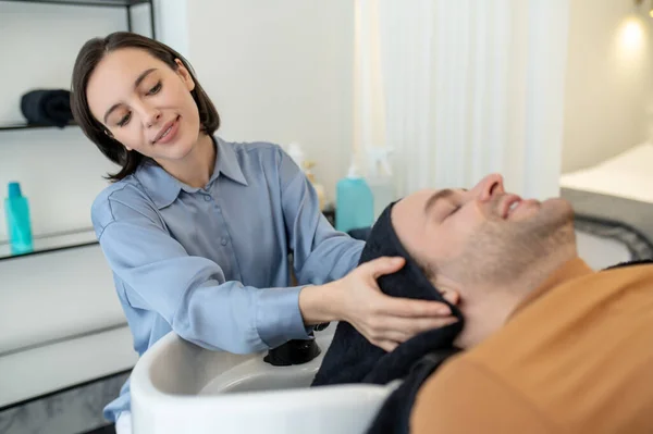 Schoonheidsspecialiste masseren mannen hoofd tijdens haarbehandeling procedures — Stockfoto