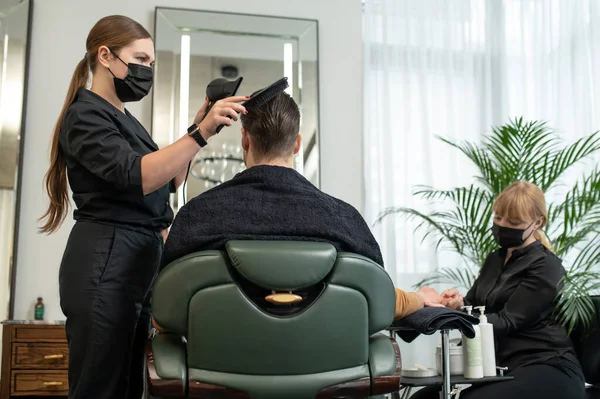 Peluquería en máscara protectora secar el cabello al cliente — Foto de Stock