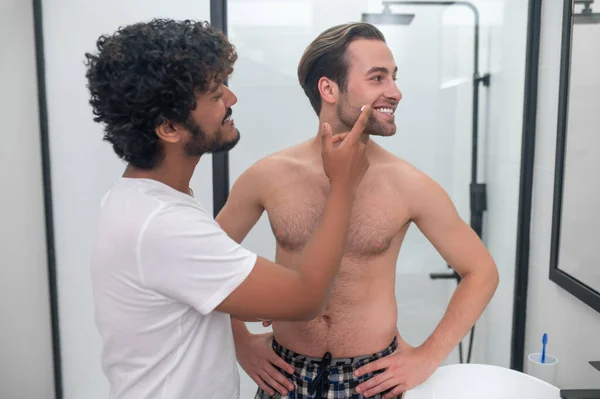 Hombre cariñoso preparando la piel de su pareja para un afeitado —  Fotos de Stock