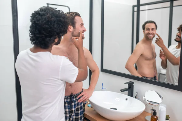 Bakıcı adam erkek arkadaşını tıraş için hazırlıyor. — Stok fotoğraf